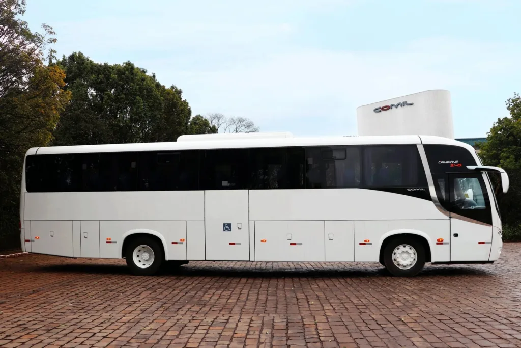Ônibus rodoviário Comil Campione 3.45 branco, visto de lado sobre piso de pedra