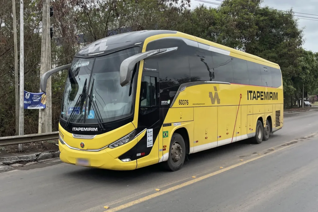 Ônibus rodoviário Marcopolo Paradiso G8 amarelo e preto visto de frente em três quartos, em rodovia