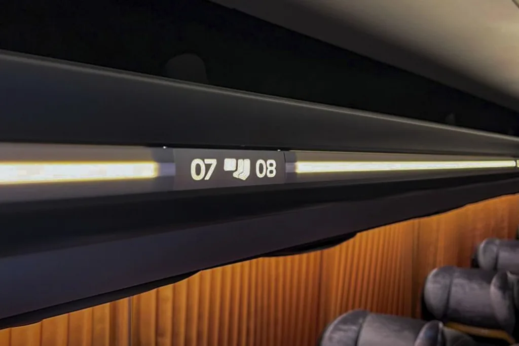 Porta-pacotes superior do ônibus Busscar Panorâmico 410, com iluminação em LED e a numeração das poltronas 07 e 08, acima das cortinas e dos encostos