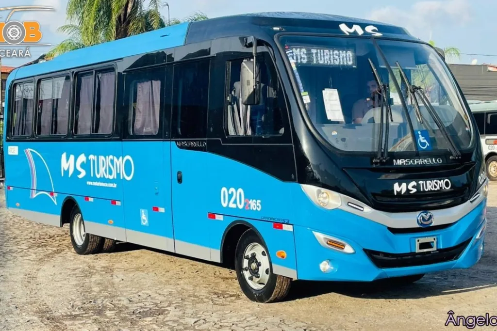 Micro-ônibus Mascarello GranMicro S3 azul da MS Turismo, vista três quartos dianteira, em pátio de paralelepípedo