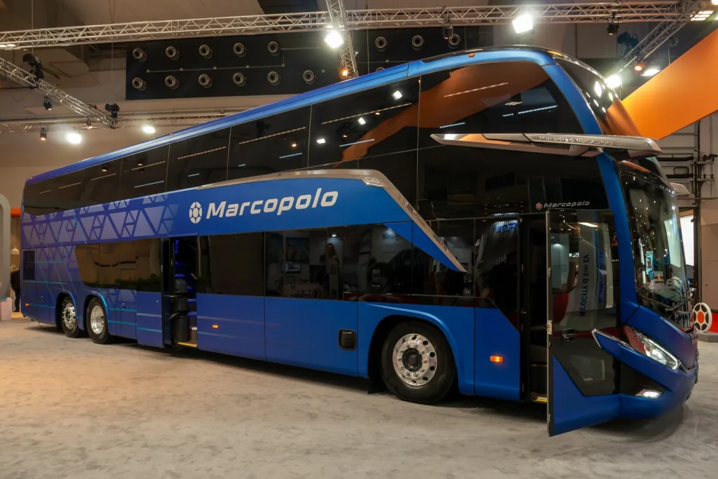 Ônibus de dois andares Marcopolo azul exposto em feira, com a porta lateral aberta